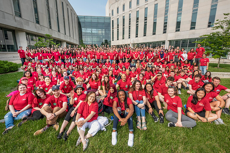 A group photo of students and staff of the language workshop posing on the lawn at HLS.