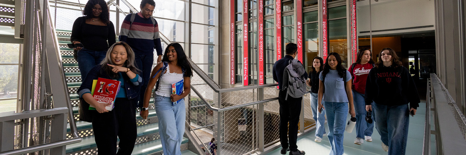 Students are walking down the stairs and across the skywalk in the HLS atrium.